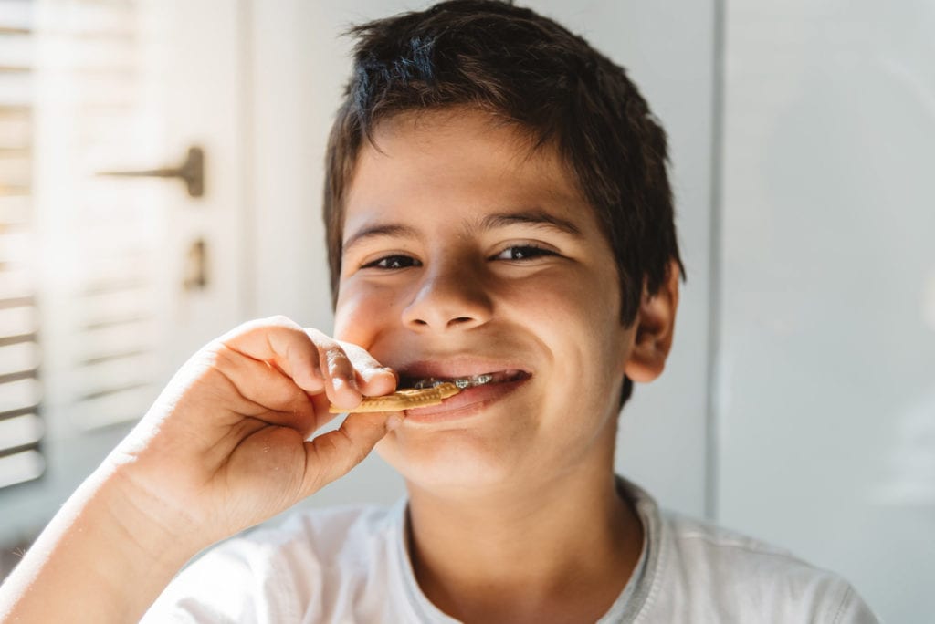 Young boy with braces eating