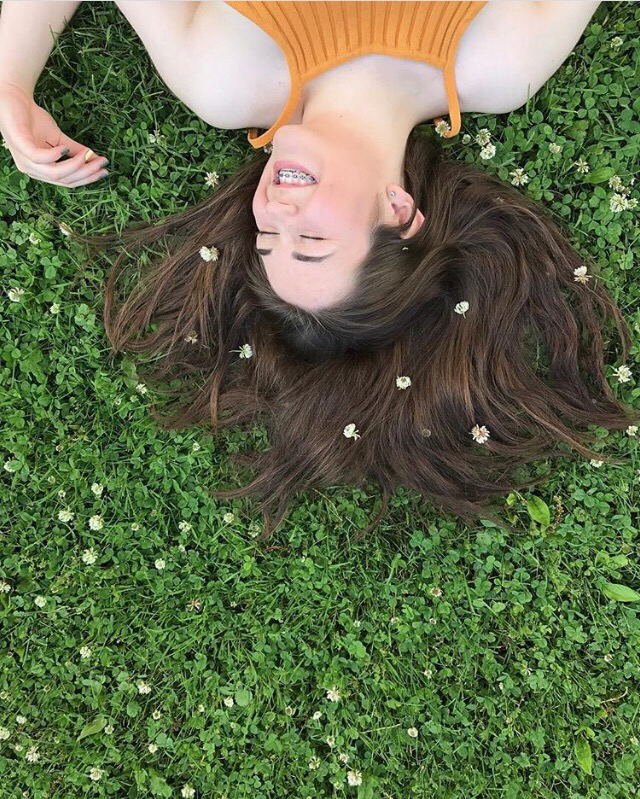 Teenage girl with braces in a grassy field